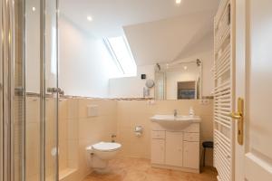 een badkamer met toilet en wastafel bij Haus Decker, App 3 in Wenningstedt