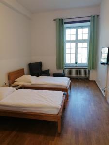 Cette chambre comprend 3 lits et une fenêtre. dans l'établissement Kloster Langwaden, à Grevenbroich