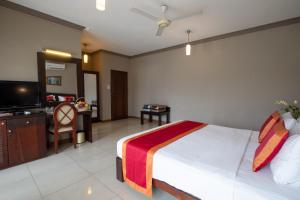 a bedroom with a large bed and a television at Kings Ridge Kandy in Kandy