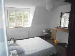 um quarto com uma cama, uma secretária e 2 janelas em Bruneval House em Dunkerque