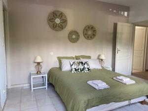 1 dormitorio con 1 cama verde y 2 toallas en Villa 180 m2 vue Mer au calme grand terrain Porticcio, en Porticcio
