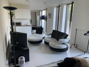 ein Wohnzimmer mit 2 Stühlen und einem TV in der Unterkunft Prachtige gastsuite in Ranst "Studio 34" in Ranst