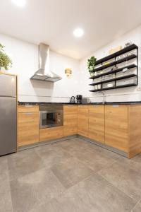 a kitchen with wooden cabinets and a stainless steel refrigerator at Unamuno by Bilbao Living in Bilbao