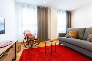 sala de estar con sofá y alfombra roja en Unamuno by Bilbao Living, en Bilbao