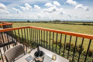 a table on a balcony with a view of the ocean at Twr y Felin Hotel in St. Davids