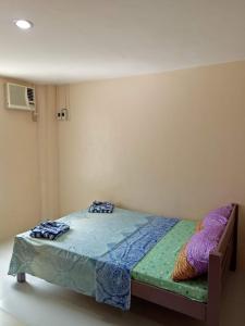 Schlafzimmer mit einem Bett mit blauer Bettwäsche in der Unterkunft BM Island Inn in Bantayan