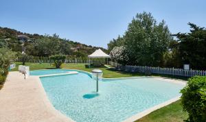 a swimming pool in a yard with a gazebo at Chia Laguna - Hotel Village in Chia