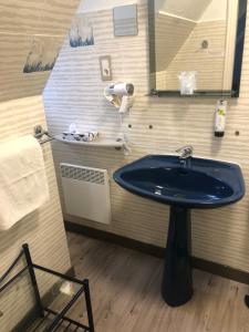 a bathroom with a blue sink and a mirror at Logis Hotel De La Corniche in Brest