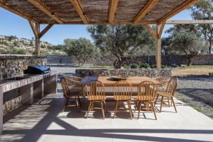een houten tafel en stoelen op een terras bij Villa al Sur in Chania +57 foto's