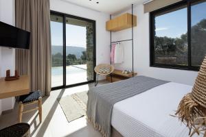 een slaapkamer met een bed, een bureau en ramen bij Villa al Sur in Chania