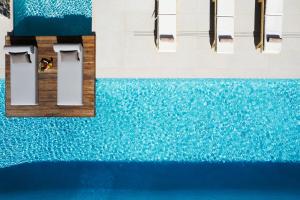 een man die op een steiger boven een plas water zit bij Villa al Sur in Chania