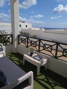 een balkon met een tafel en uitzicht op het strand bij Apartment Portonovo Paraiso II - Sea View - Piscina - Wifi - Old Town in Puerto del Carmen