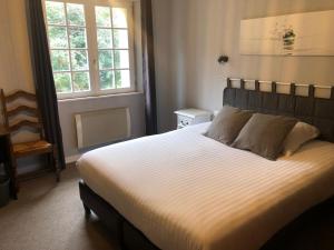 a bedroom with a large bed and a window at Logis Hotel De La Corniche in Brest