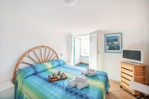 Un dormitorio con una cama con una bandeja de comida. en Porto Sole Apartment by Wonderful Italy, en San Remo