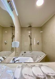 a large bathroom with a tub and a large mirror at OPERA16 Guestrooms in Budapest +102 photos