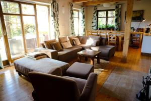 ein Wohnzimmer mit Sofas, einem Tisch und Fenstern in der Unterkunft Chata u Gregora v Slovenskom raji in Smižany