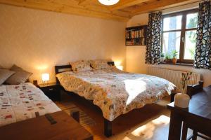 sypialnia z łóżkiem, stołem i oknem w obiekcie Chata u Gregora v Slovenskom raji w mieście Smižany