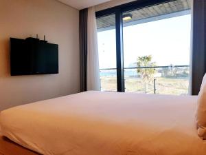מיטה או מיטות בחדר ב-Jeju Attirance