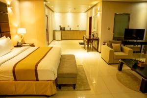 una camera d'albergo con letto e soggiorno di Palm Africa Hotel Juba a Giuba