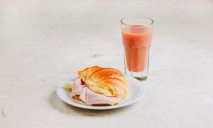 a sandwich on a plate next to a glass of juice at RM The Experience - Small Portuguese Hotels in Setúbal