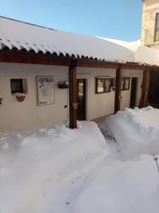 dom pokryty śniegiem obok budynku w obiekcie Azienda Agricola Mappavel's w mieście Castel del Monte +8 zdjęć