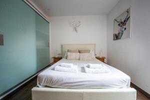 a bedroom with a large white bed with two pillows at Design club Barcelona in Hospitalet de Llobregat