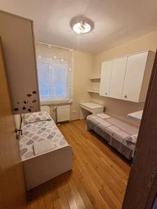 mała sypialnia z łóżkiem i oknem w obiekcie APARTMAN DOKOZA FREE PARKING w mieście Zadar