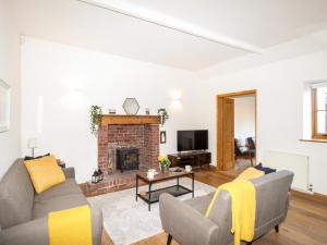 ein Wohnzimmer mit einem Sofa und einem Kamin in der Unterkunft The Stables in Weymouth