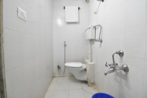 a white bathroom with a toilet in a stall at BALAS RESIDENCY in Mumbai