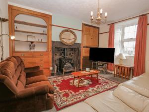 a living room with a couch and a fireplace at Beckside Farm in Millom