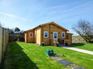een klein houten huis in een grasveld bij Aurora Skies in Cresswell