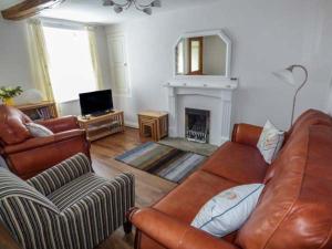 a living room with a couch and a fireplace at Corner Cottage in Kirkby Stephen