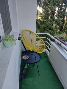 a yellow chair sitting on a balcony next to a window at Apartament Marasesti in Piteşti
