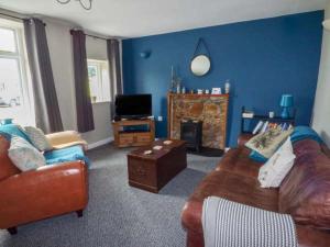 uma sala de estar com um sofá e uma televisão em Corner Cottage em Reynoldston