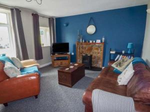 a living room with a couch and a tv at Corner Cottage in Reynoldston