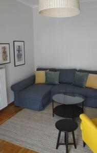 sala de estar con sofá azul y mesa en Illisia Roof Apartment, en Atenas