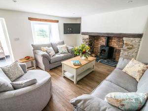 uma sala de estar com dois sofás e uma lareira em Five Elements Cottage em St. Agnes