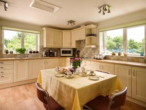 a kitchen with a table with a yellow table cloth on it at Shepherds Rest in Warbstow