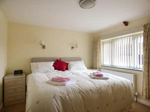 um quarto com uma cama com duas almofadas e uma janela em Shepherds Rest em Warbstow
