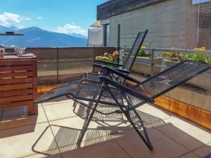 a black chair sitting on top of a balcony at Studio Jeanne d'Arc-9 by Interhome in Crans-Montana