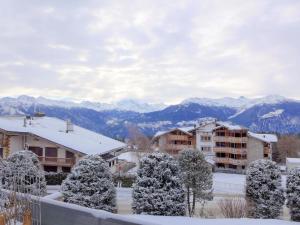 a city with snow covered trees and buildings and mountains at Studio Jeanne D'Arc Apt- E-36 by Interhome in Crans-Montana