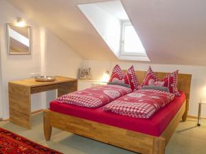 ツェル・アム・ゼーにあるChalet Ferienhaus Dr-Steiner by Interhomeの赤い枕が付いたベッドが備わる客室です。