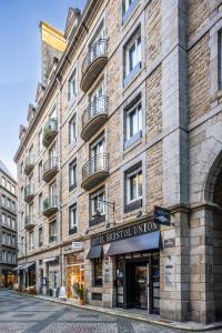 a large brick building with a hotelinsteinination union on a street at Hôtel Bristol Union Intra Muros in Saint Malo