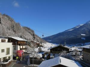 un pueblo en las montañas con nieve en los tejados en Apartment Liftblick - NKI190 by Interhome, en Neukirchen am Großvenediger