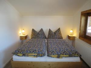 1 dormitorio con 1 cama con 2 almohadas y 2 lámparas en Apartment Liftblick - NKI190 by Interhome, en Neukirchen am Großvenediger
