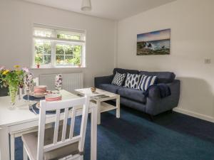 a living room with a couch and a table at Sea Breezes in Newquay