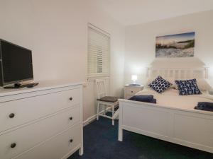 a bedroom with a bed with a tv on it at Sea Breezes in Newquay