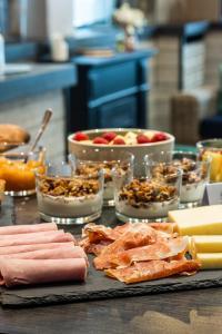 uma mesa com um monte de comida e tigelas de comida em Hôtel Bristol Union Intra Muros em Saint Malo