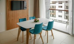 a dining room with a white table and blue chairs at Zephyr Agadir in Agadir