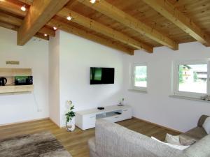 Elle comprend un salon doté de murs blancs et de plafonds en bois. dans l'établissement Apartment Lili - LFD120 by Interhome, à Längenfeld